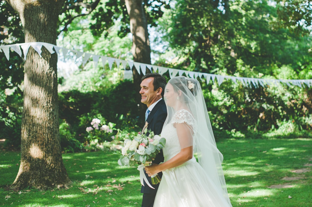 Wedding guests walking a farm road at Muldersvlei beneath strings of country bunting