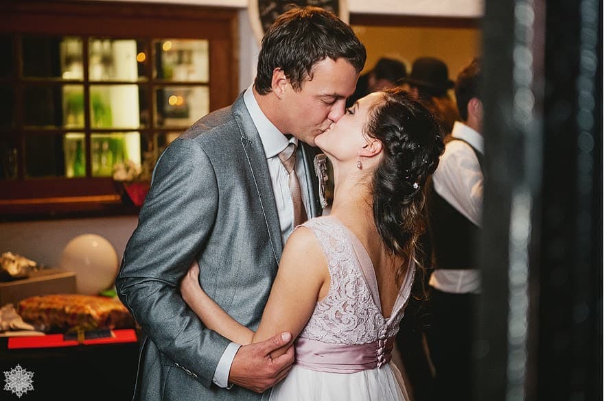 A bride and groom kissing at their evening reception in the Old Cellar at Muldersvlei