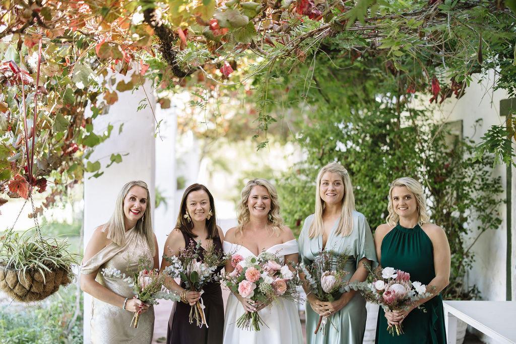 Bridesmaids laughing together among the vines at Muldersvlei
